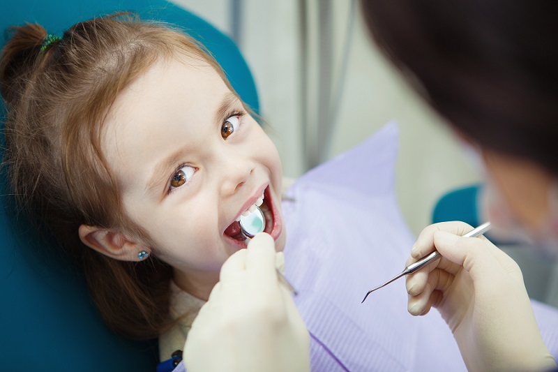 Enfant heureux dans un fauteuil de dentiste confortable