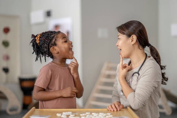 qu'est ce que la rééducation linguale Une orthophoniste guide une patiente enfant dans un exercice de rééducation linguale.